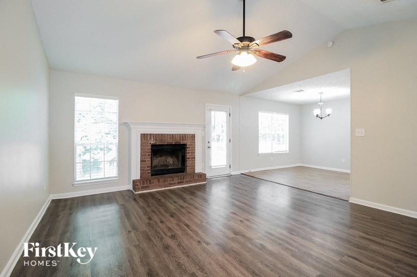 a living room with a fireplace and a ceiling fan