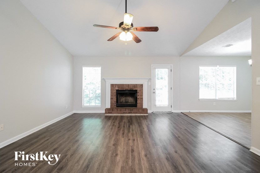 a living room with a fireplace and a ceiling fan