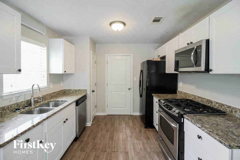 a kitchen with white cabinets and stainless steel appliances