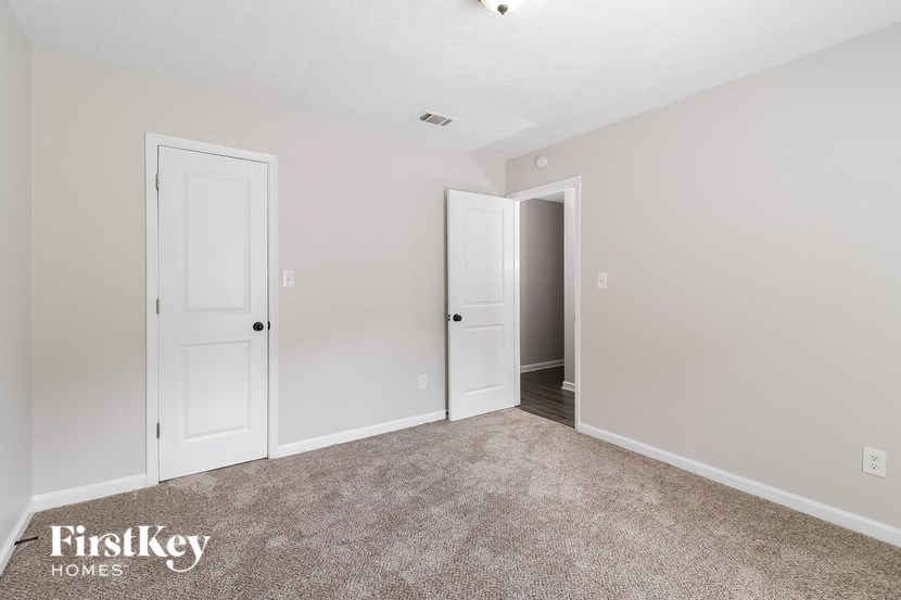 a bedroom with two doors and a carpeted floor