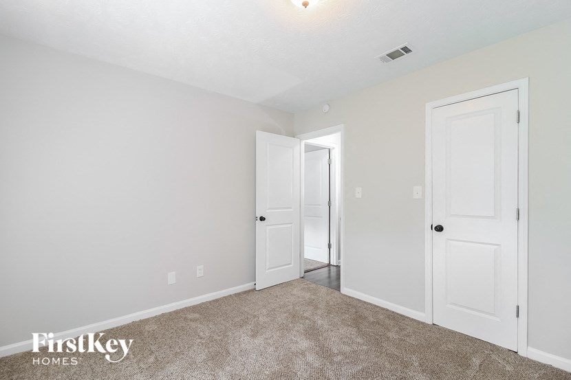 a bedroom with two white doors and a carpeted floor