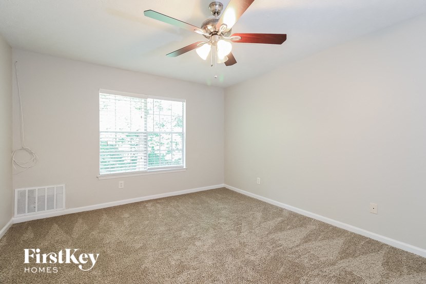 the master bedroom has a carpeted floor and a ceiling fan