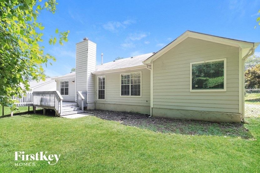 a small yellow house with a porch and a deck