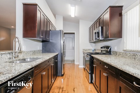 a kitchen with wooden cabinets and granite counter tops and stainless steel appliances