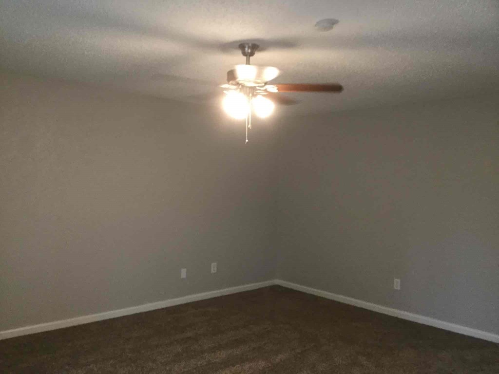 a empty room with a ceiling fan and a light
