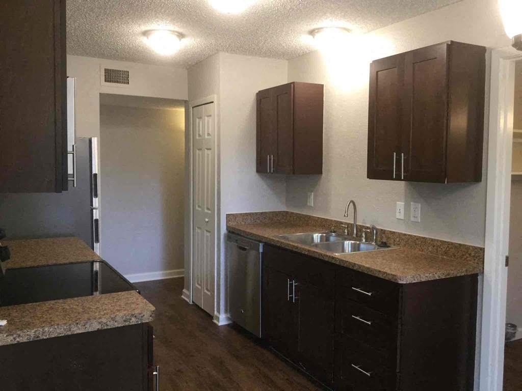 an empty kitchen with a sink and counters in a house