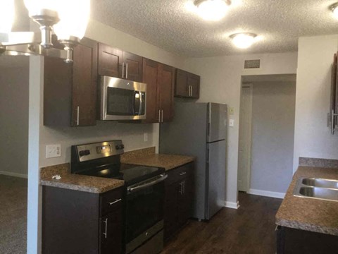a kitchen with black cabinets and stainless steel appliances