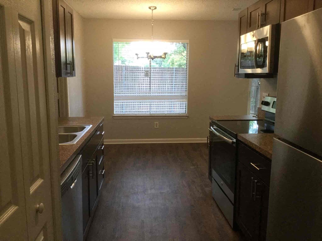 an empty kitchen with a large window in the middle of it