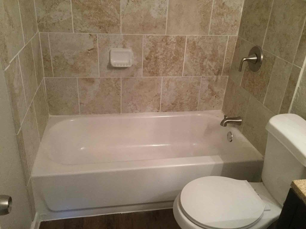 a bathroom with a toilet and a bath tub