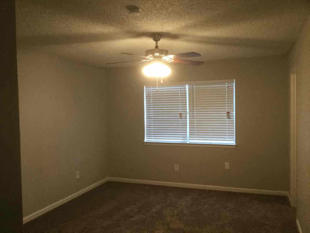 a bedroom with a ceiling fan and a window