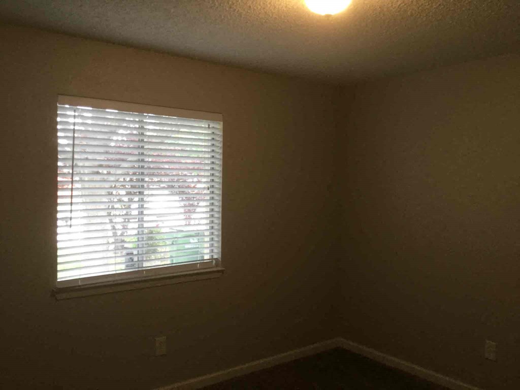 an empty room with a window and a light on the ceiling