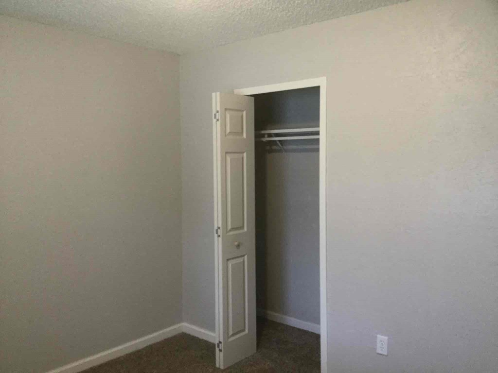 an empty closet in a room with a door open