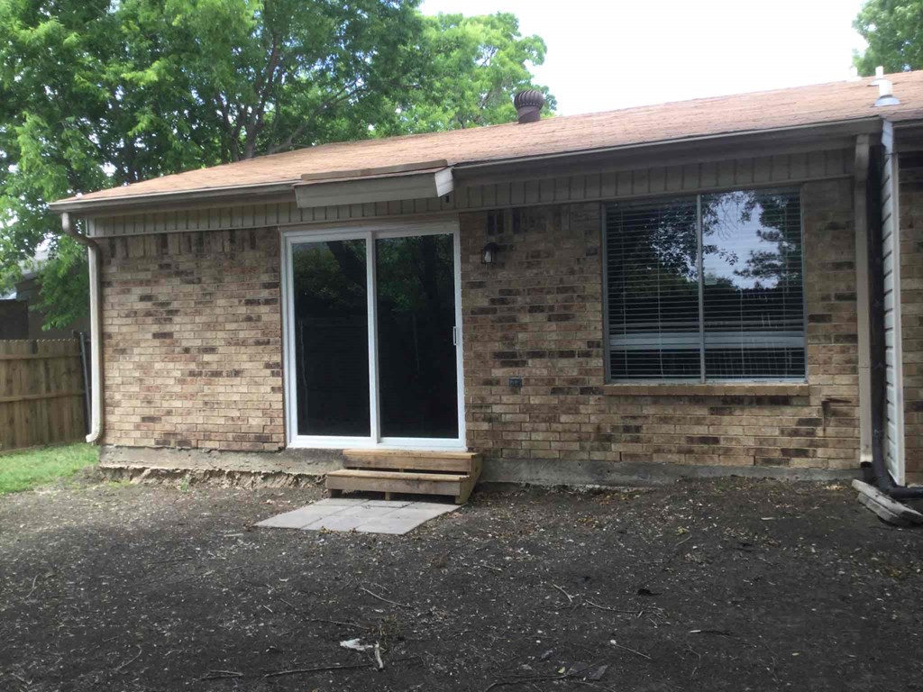 the front of a brick house with a door and a window