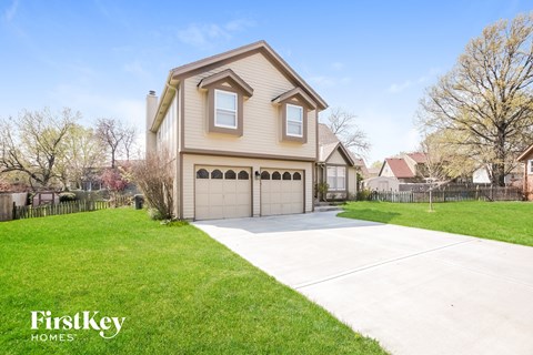 a beige house with a garage and a driveway