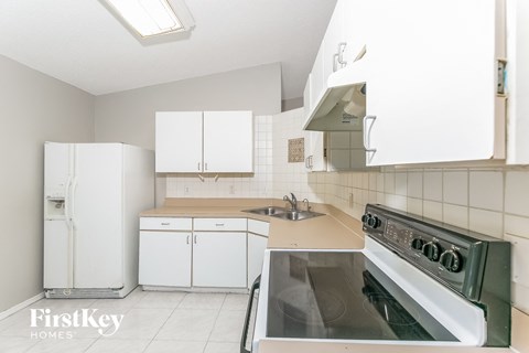 a kitchen with white cabinets and a stove and a sink