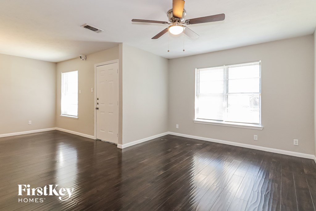 A room with a wooden floor and a ceiling fan.