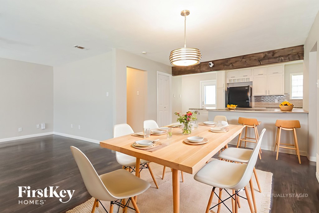 A dining room with a wooden table and chairs.