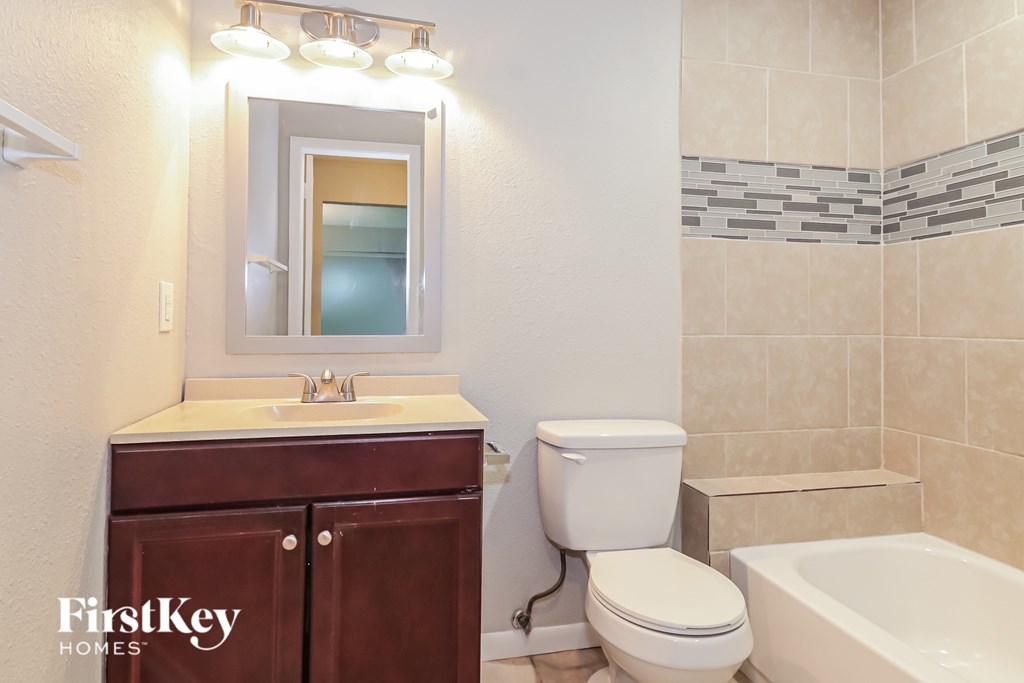 A bathroom with a white toilet and a brown cabinet.