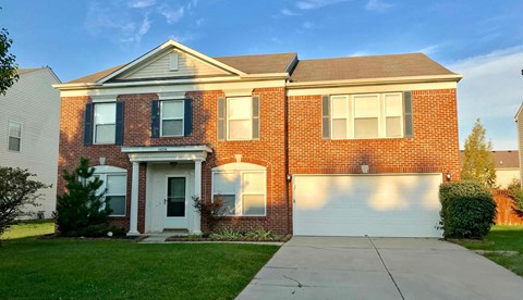 A red brick house with a white garage door.