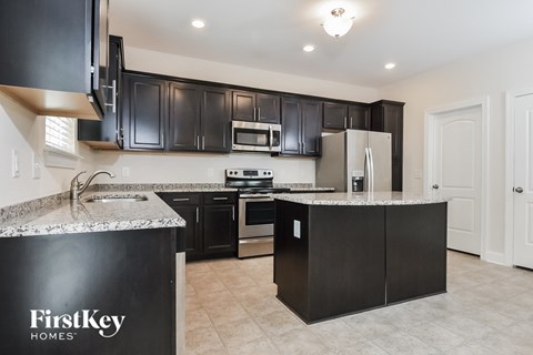 a kitchen with black cabinets and granite counter tops
