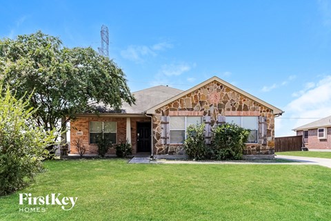 a small brick house with a garage and a lawn