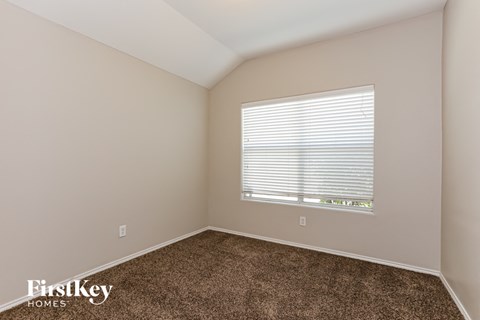 the upstairs bedroom has carpet and a large window