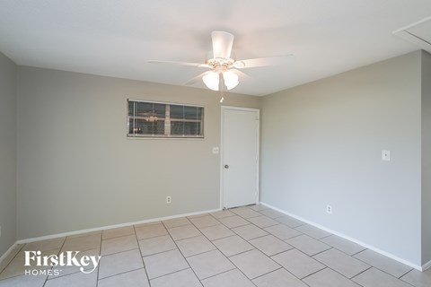a living room with a ceiling fan and a tiled floor