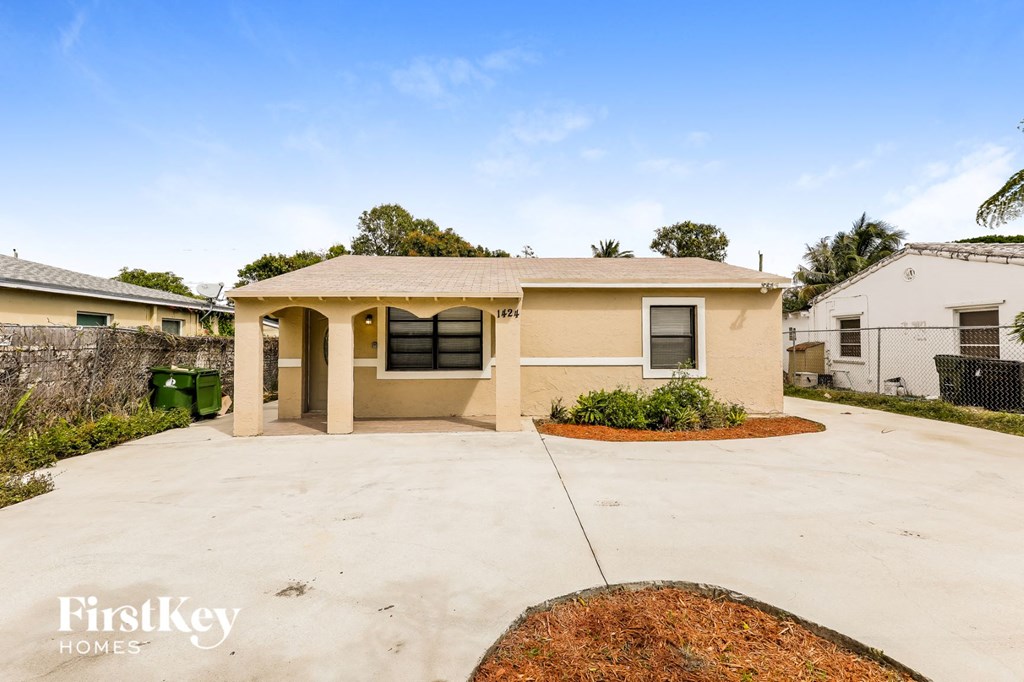 A house with a brown roof and a white wall is shown with a FirstKey Homes logo.