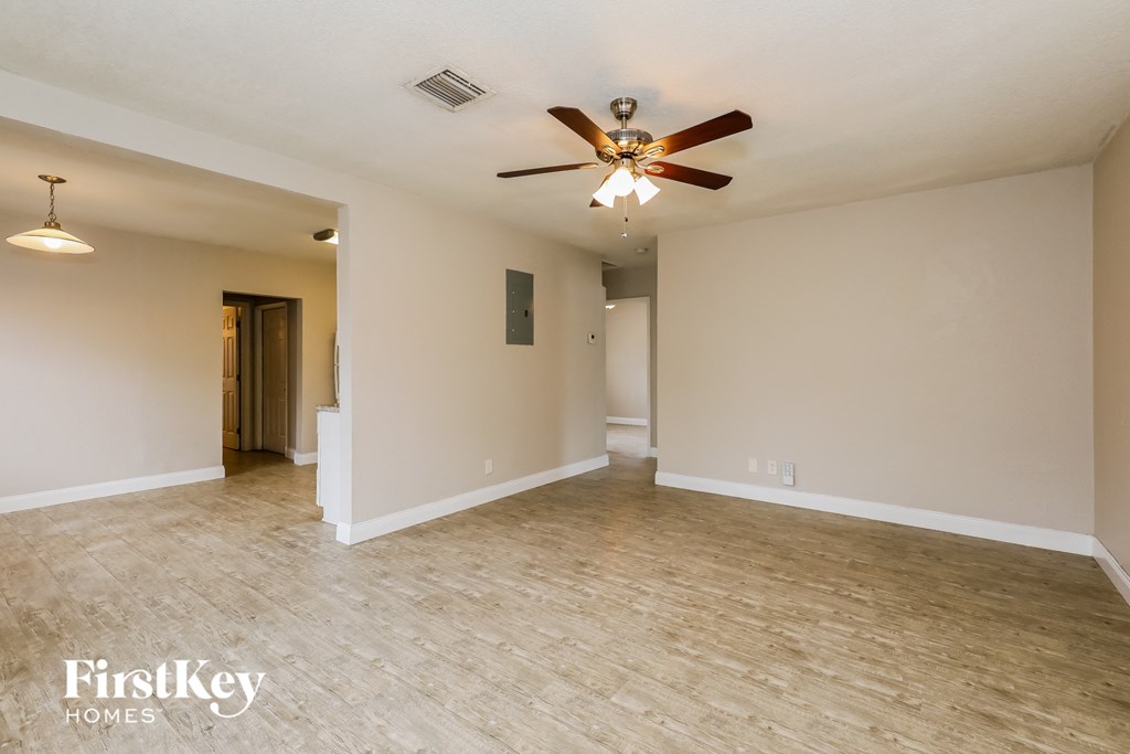 A spacious room with a ceiling fan and light fixture.