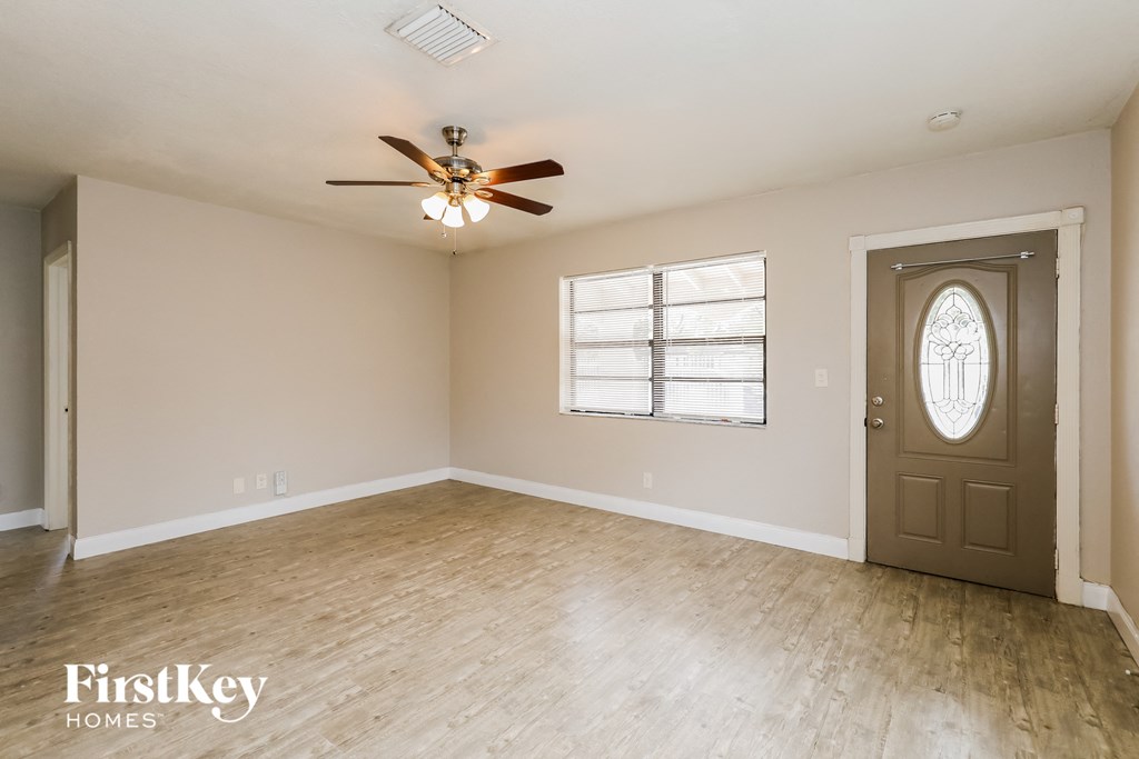 A room with a ceiling fan and a door.