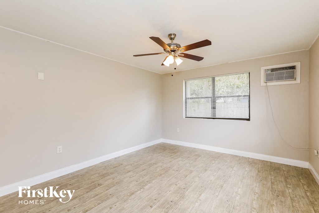 A room with a ceiling fan and a window.
