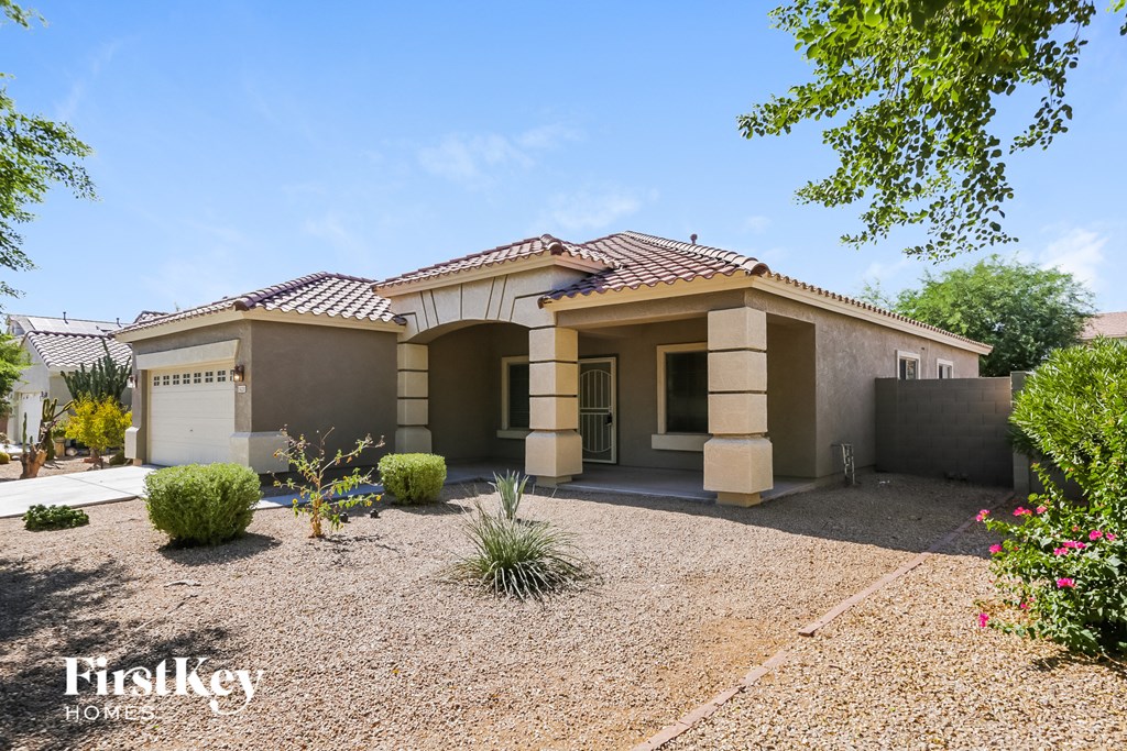 a small house with a gravel yard and a driveway