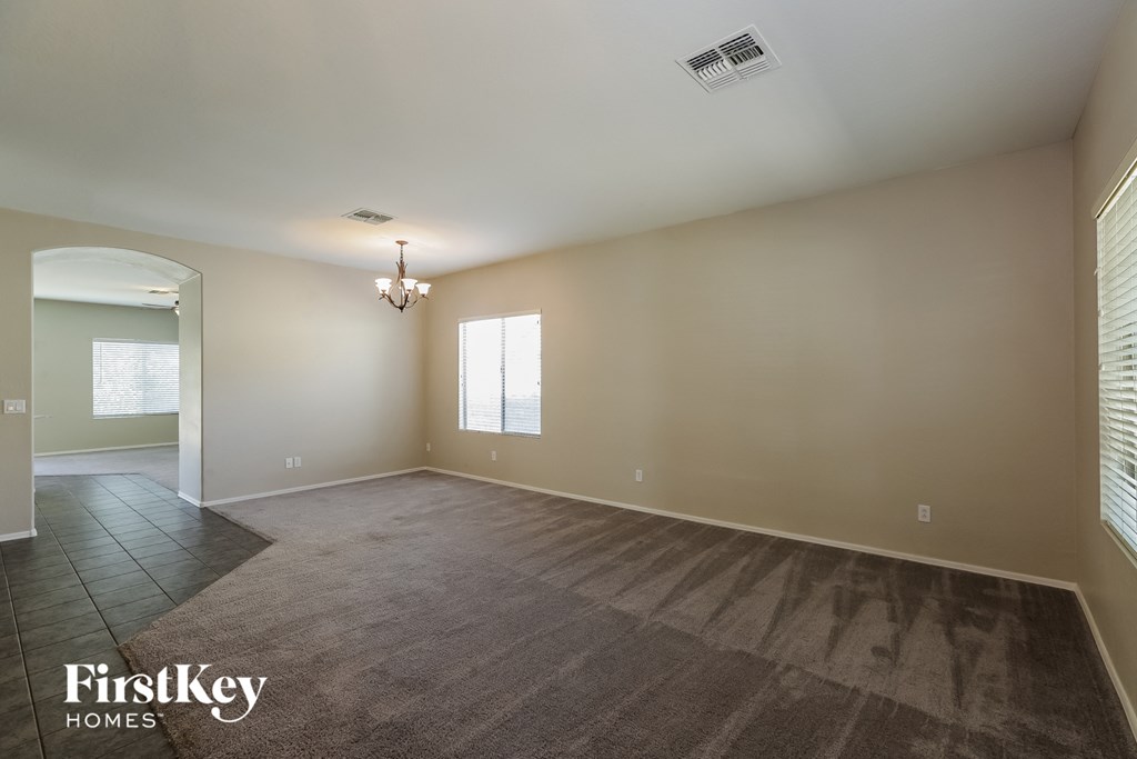 a empty living room with a carpeted floor and a window