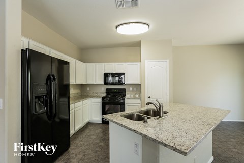 a kitchen with granite counter tops and black appliances