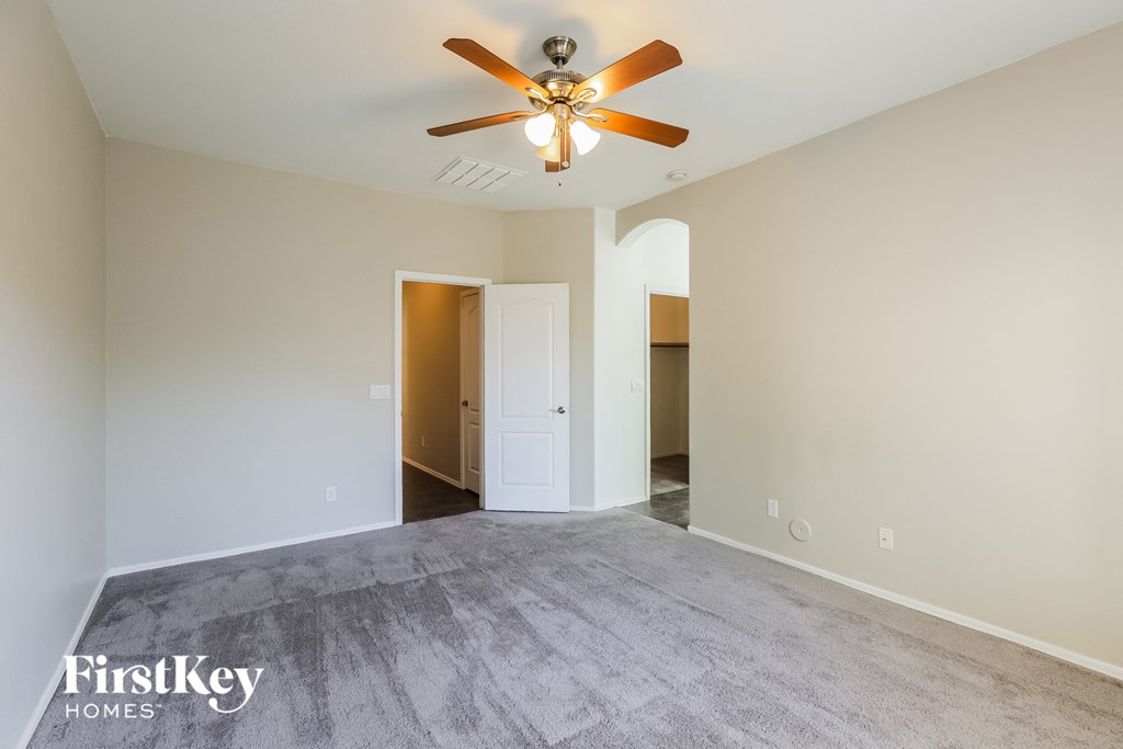 the living room of an empty house with a ceiling fan