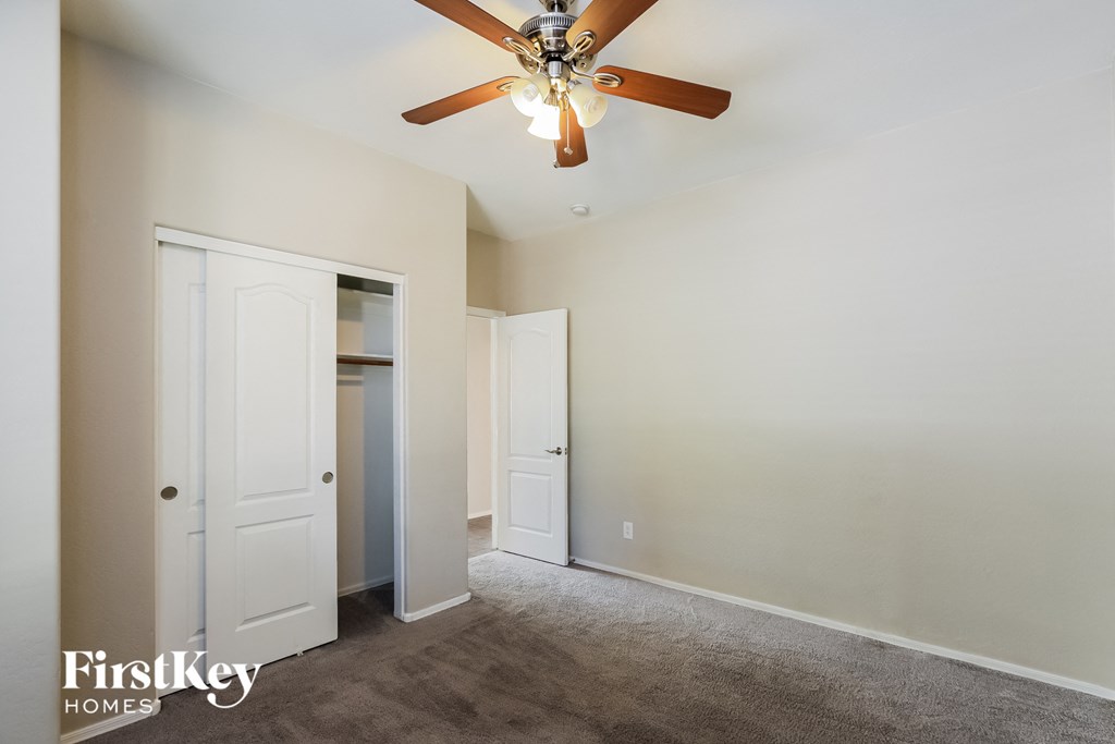 a bedroom with a ceiling fan and a closet