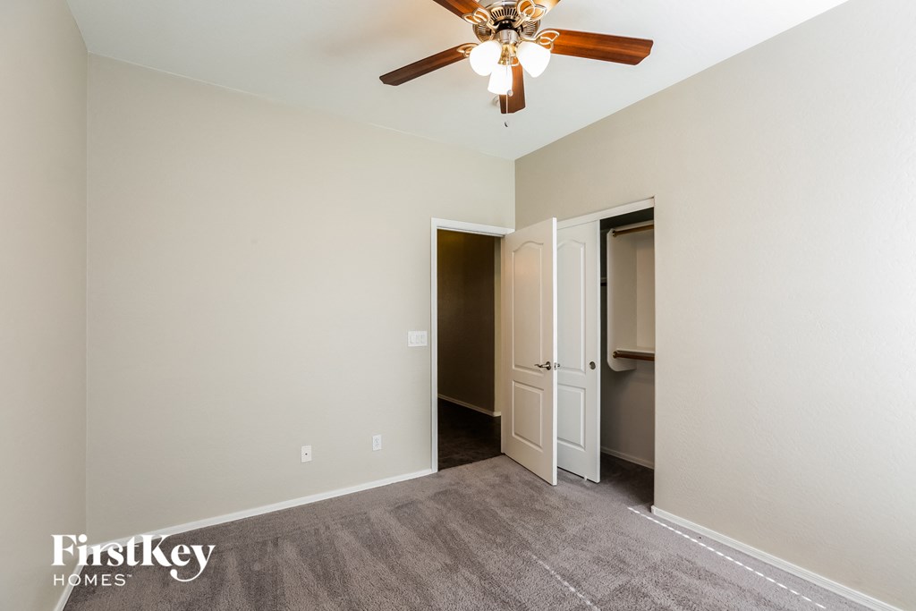 a living room with a ceiling fan and a door to a closet