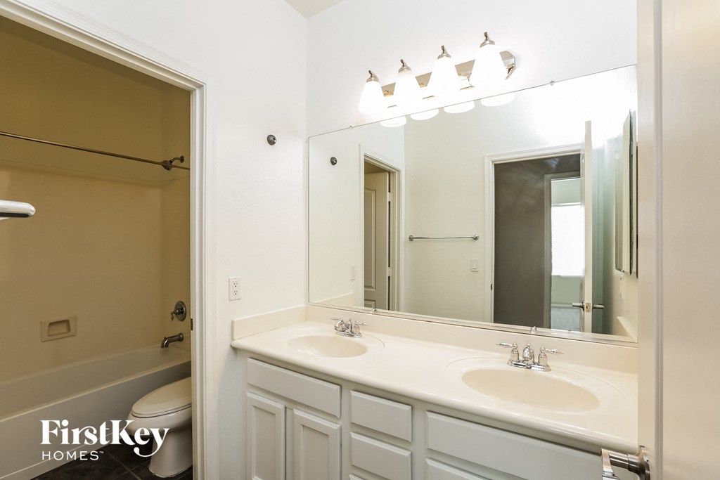 a white bathroom with two sinks and a mirror