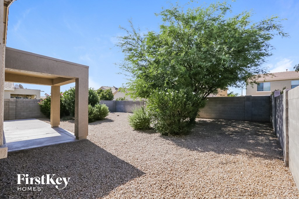 a backyard with a tree and a wooden deck