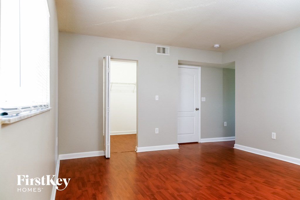 an empty living room with wood floors and white walls