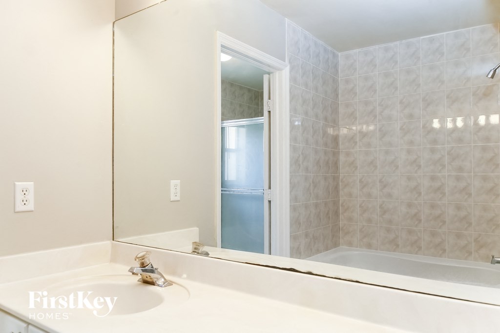 a bathroom with a large mirror and a tub and shower
