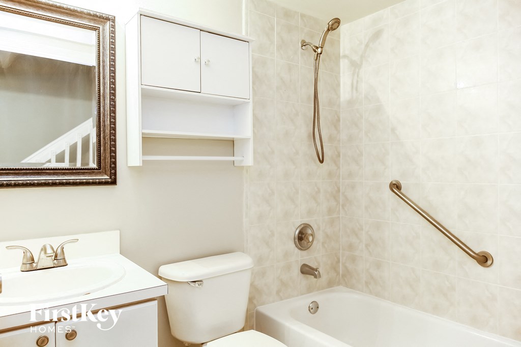 a bathroom with a shower toilet and sink and a mirror