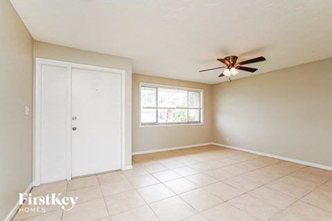 A room with a ceiling fan and a door.