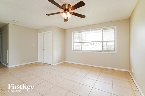 A room with a ceiling fan and a window.