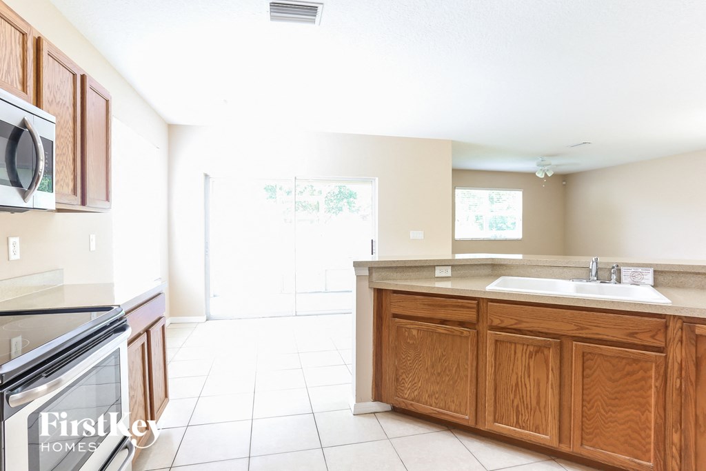 a kitchen with wooden cabinets and a sink and a stove