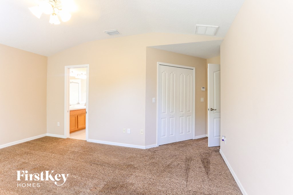 a bedroom with a carpeted floor and a white door