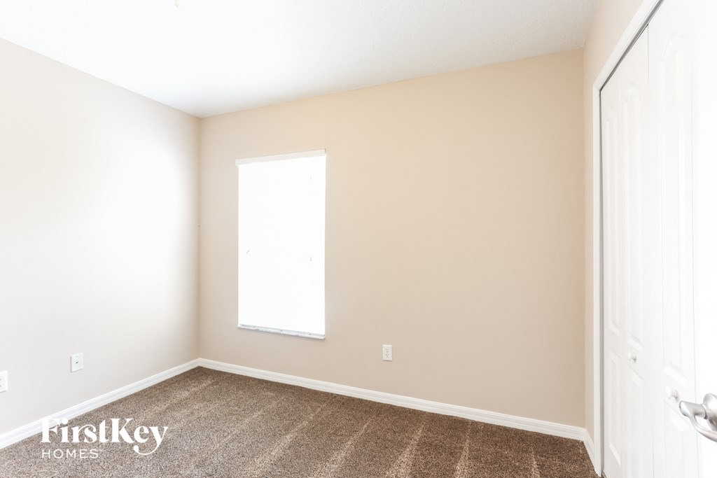 a empty room with carpet and a window