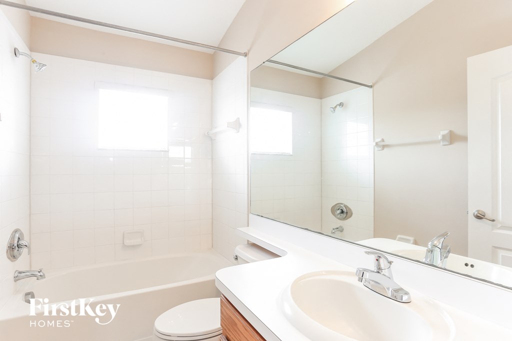 a bathroom with a sink and a tub and a mirror