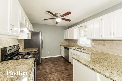 A kitchen with a stove top oven, refrigerator, and a counter top.