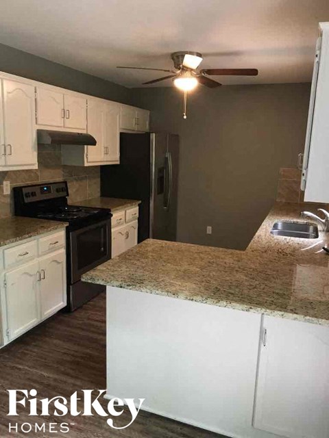a kitchen with white cabinets and a granite counter top